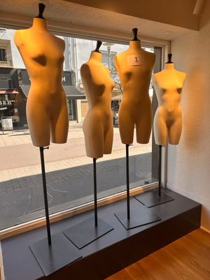 trois mannequins exposés devant la vitrine d'un magasin