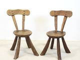these are two wooden chairs sitting next to each other on a white floor