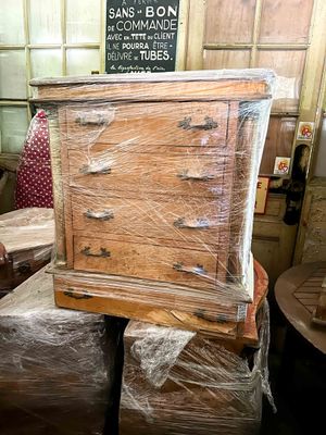 a man standing next to a wooden dresser in a room