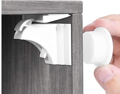 quelqu'un ouvre la porte d'un placard à l'aide d'un loquet blanc