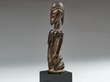 a wooden statue of a man with a helmet on his head