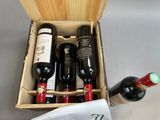 bottles of wine are in a wooden box on a table