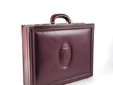 a brown briefcase sitting on a white surface
