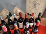 several bottles of wine are lined up on a red table