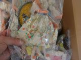 a person holding a box full of dolls in it