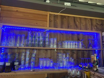 a shelf with glasses and bottles on it in a room