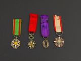 five medals and a cross are on a black surface