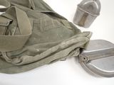 a green bag with a metal container on it