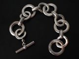 a close up of a chain bracelet with a silver clasp