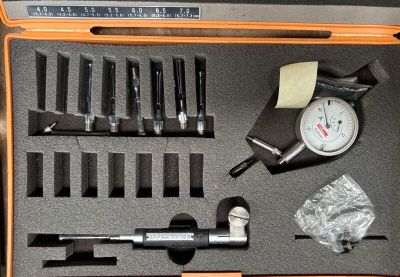 une trousse à outils dans un coffret comprenant un calibre, une clé à molette et d'autres outils