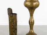 two brass vases sitting next to each other on the floor