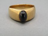 une image représentant une bague en or sertie d'une pierre noire