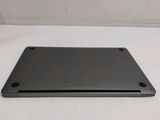 the back of a laptop computer sitting on top of a white table