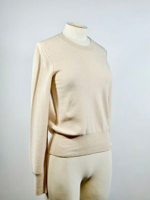 un mannequin vêtu d'un pull beige et d'un short