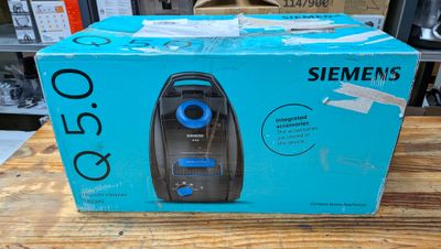 un carton contenant un aspirateur posé sur une table en bois