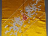 une nappe en soie jaune sur laquelle sont représentés un dragon et un autre dragon