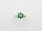 an emerald and diamond flower ring