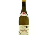 the bottle of white wine is sitting on a white surface