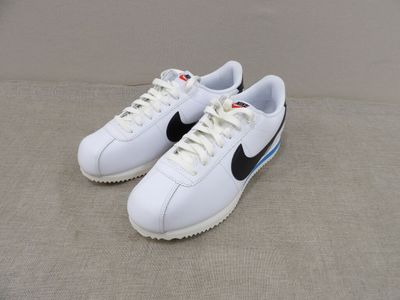 une paire de baskets blanches ornées de rayures noires et bleues