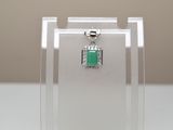 un petit pendentif de forme carrée orné d'une pierre verte