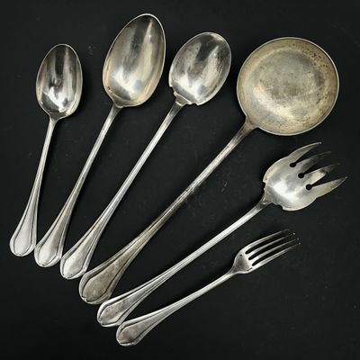 six cuillères en argent et deux cuillères en argent sur un fond noir