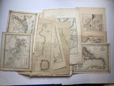 Plusieurs vieilles cartes du monde sont étalées sur une table