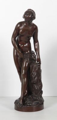 statue en bronze représentant une femme assise sur un rocher, les mains posées sur les genoux