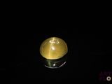 une pomme jaune posée sur une surface noire
