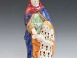 figurine d'une femme tenant un enfant dans ses bras