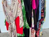 a lot of clothes hanging on a rack in a room