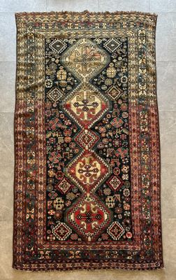 Un tapis persan ancien est posé au sol.