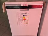 a white dishwasher sitting next to a pink dishwasher in a store