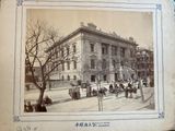 an old picture of a large building with people walking around it