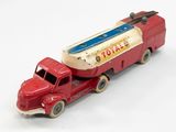 un camion jouet rouge avec une remorque blanche et bleue attelée