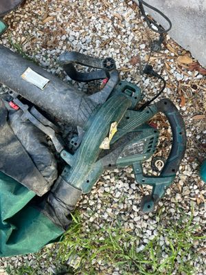 a green lawn mower that is laying on the ground