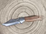 a knife that is sitting on top of a piece of wood
