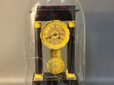 a small clock under a glass dome on a table