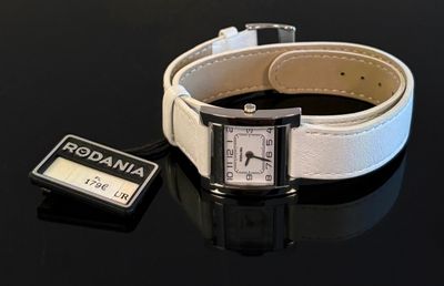 une montre blanche et une montre noire posées sur une table noire