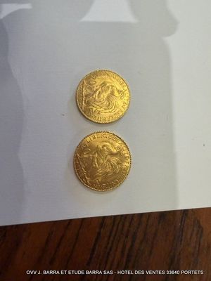 deux pièces d'or posées sur une feuille de papier blanc