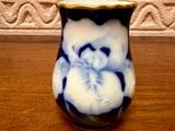 a blue and white vase sitting on a wooden table