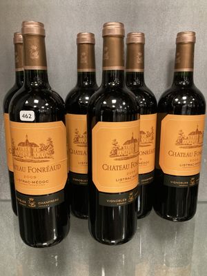 Six bouteilles de Château Fonnéaux sont alignées sur une table en verre.