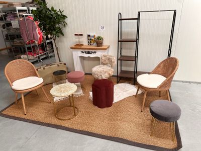 Plusieurs chaises et tabourets sont disposés sur un tapis dans une pièce