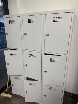 Dans une pièce, plusieurs casiers blancs sont empilés les uns sur les autres.