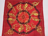 une écharpe rouge ornée de motifs dorés et noirs