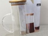 a glass cup with a wooden lid and a glass mug with a wooden lid
