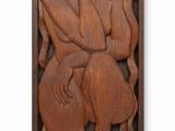 a wooden relief of a woman holding a child in her arms