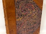 un vieux livre avec une couverture marron et une étiquette dessus
