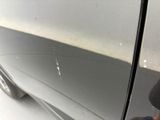 the car door of a silver car with scratches on it