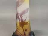 a glass vase with a flower on it sitting on a table