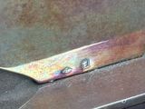 a piece of metal that has been cut in half with a pair of scissors